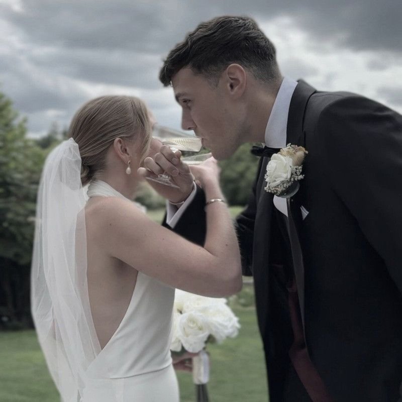 Linked arms taking their first drink as a married couple