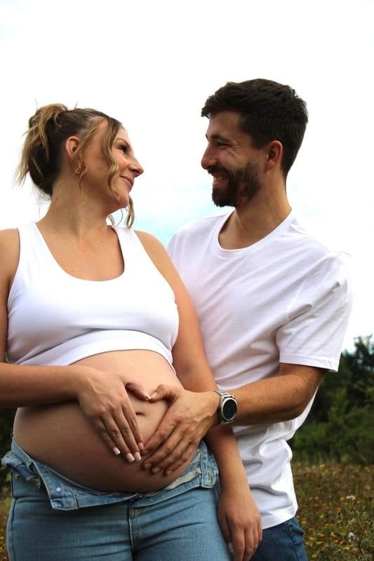 Love locked eyes while creating a heart with their hands on Mums tummy